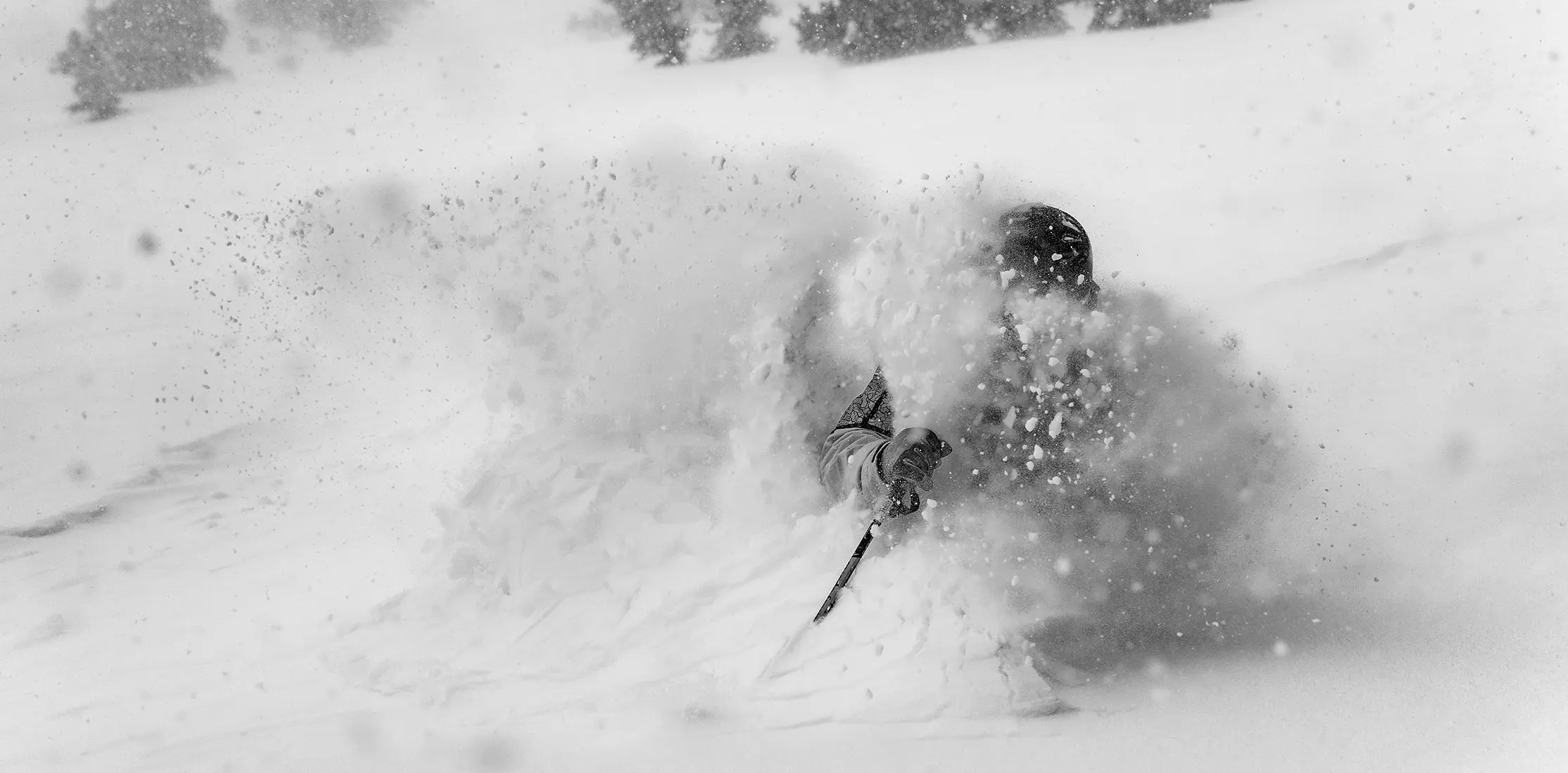 Black and white photo of a skier in deep snow for black friday