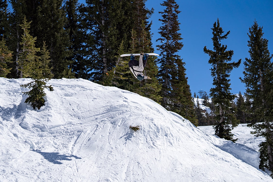 Snowboarder Harrison Fitch backflipping at Snowbird during Spring Skiing