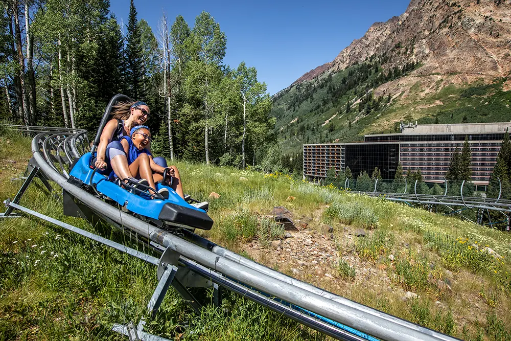 Family on Mountain Coaster in front of Cliff Lodge