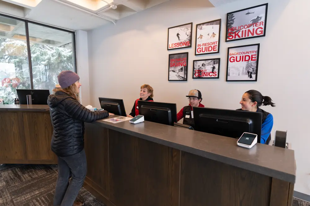 Guest at Mountain Center talking to Snowbird employees at desk