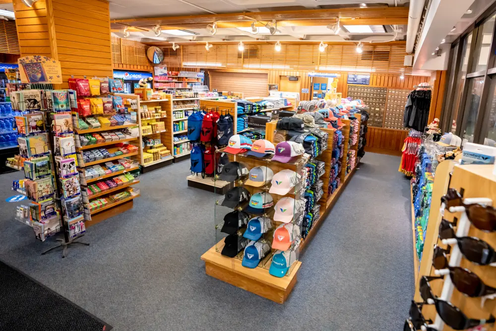 Hats and other snowbird logo items on racks at Snowbird Center Sundries