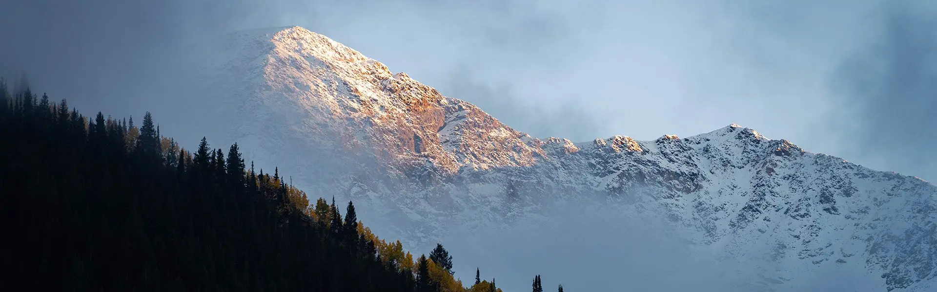 Play Forever hero image, Hidden peak in the clouds with a dusting of snow