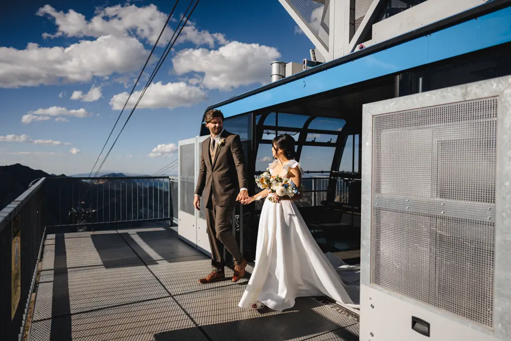 Wedding couple steps out of the Tram at Hidden Peak on The Summit of Snowbird