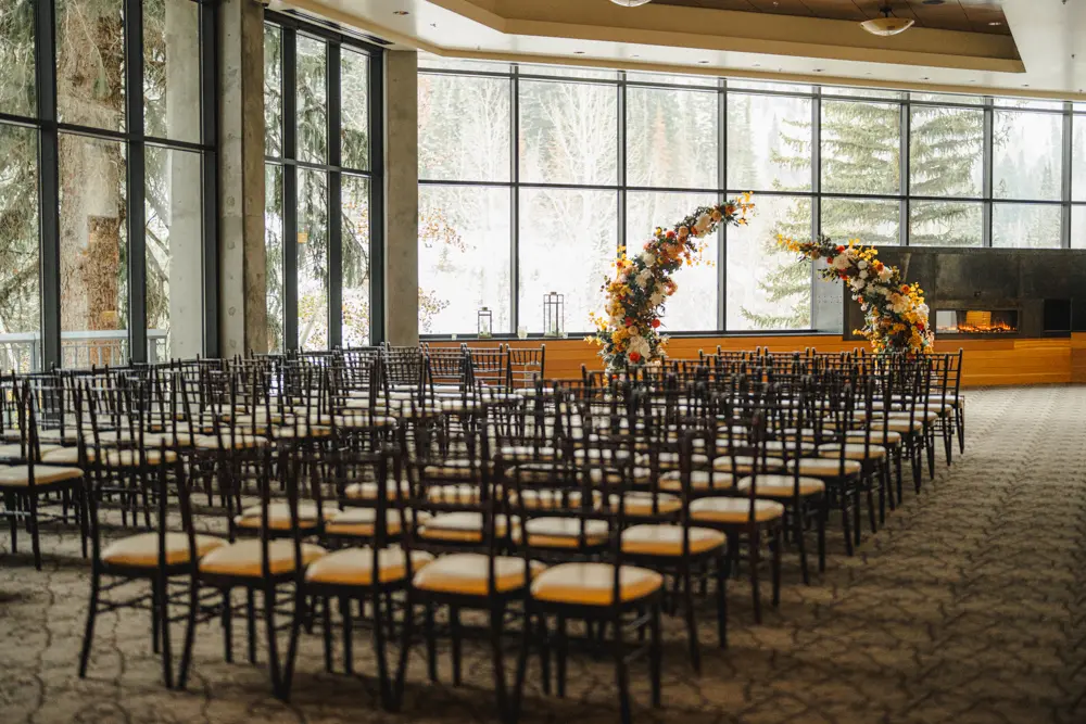 The Golden Cliff set up for a wedding ceremony with chairs and a floral arch