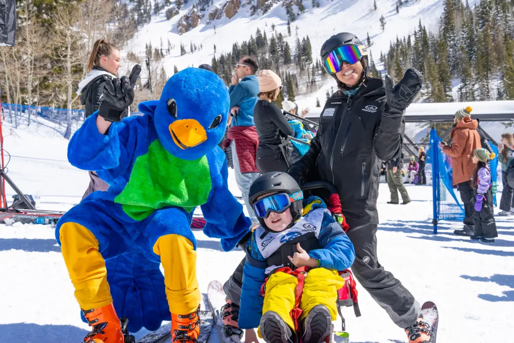 Wasatch Adaptive Sports event, The Steve Young Classic, at Snowbird. The Snowbird mascot poses with someone in a sit-ski