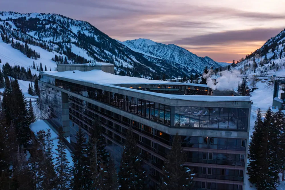 View of the Cliff Lodge with the sunset behind it. The Cliff Lodge houses some of Snowbird's event venues and restaurants
