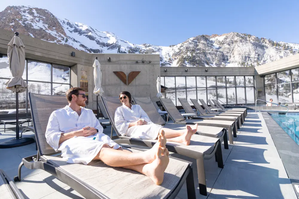 Couple sitting by the pool at The Cliff Spa in white robes