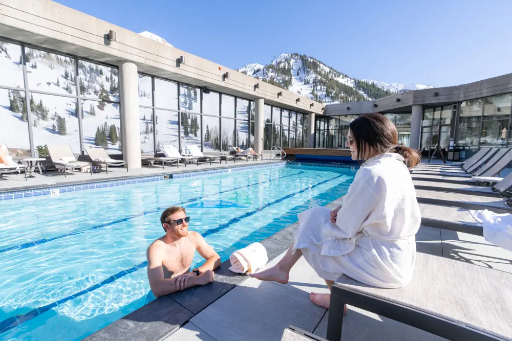 Couple at the Cliff Spa chat in the pool while enjoying their vacation with the Mountain Collective pass