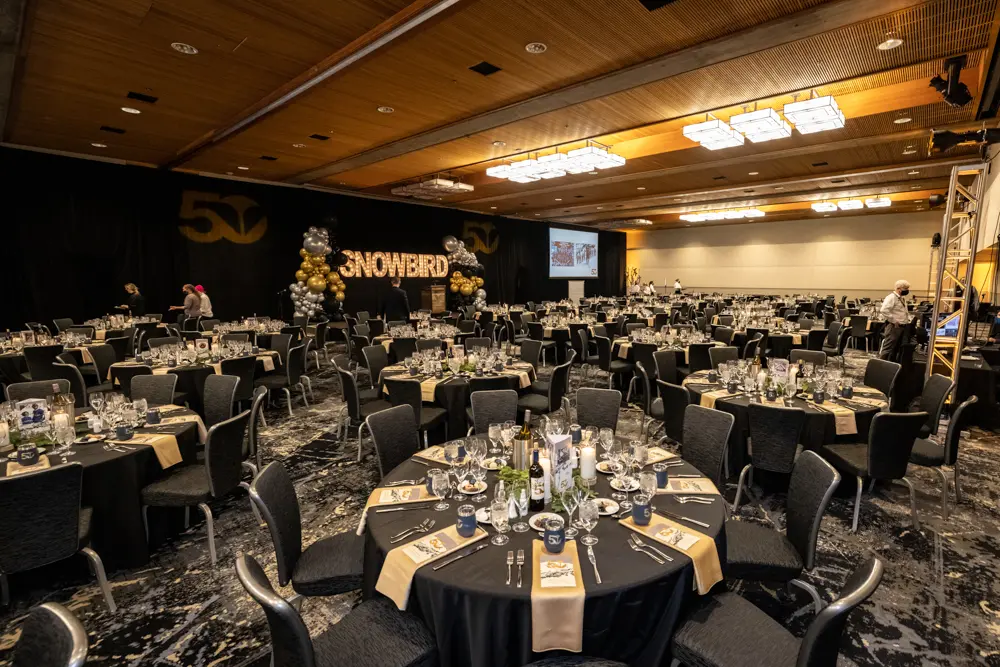 A banquet set up at Snowbird with round tables and black table clothes