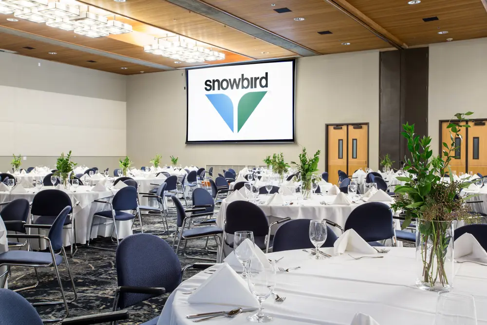 A venue at Snowbird set with tables with white table clothes.
