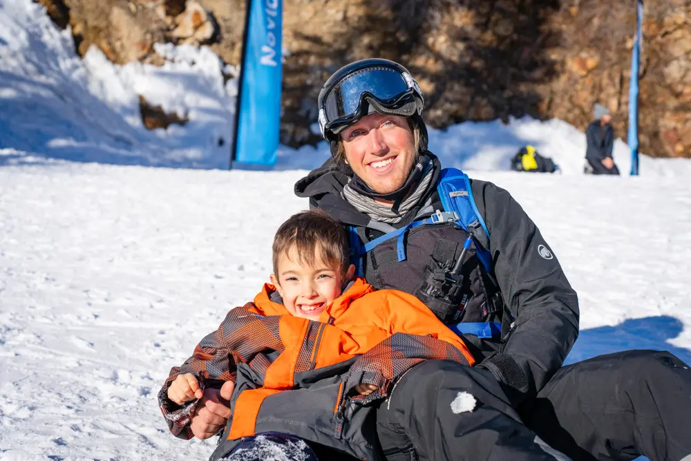 Wasatch Adaptive Sports volunteer with a kid skiing