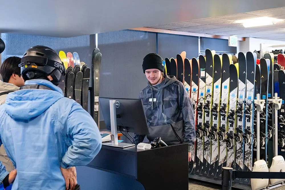Employee at Snowbird rental shop checks out customers renting gear