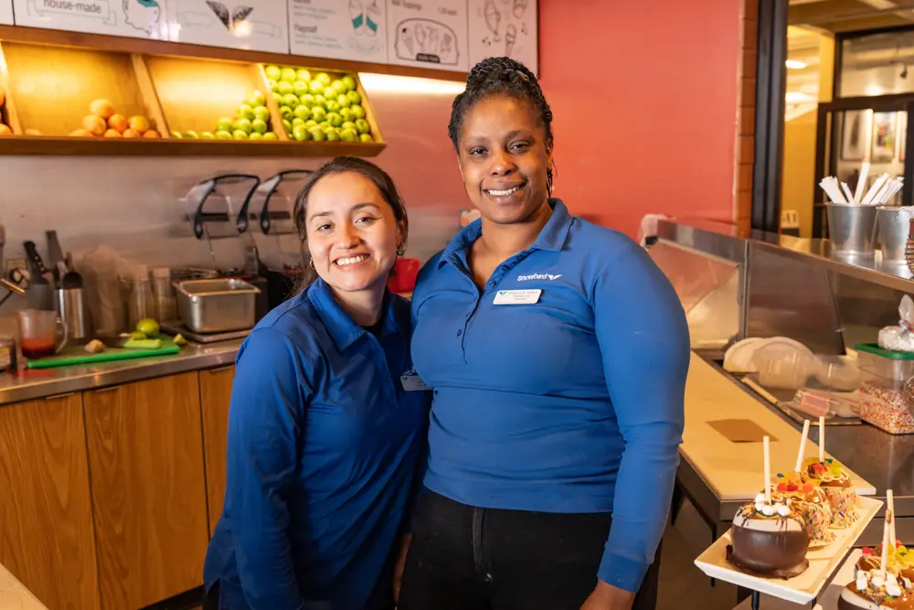 2 Beans & Brews Employees in Snowbird T-shirts pose for a picture
