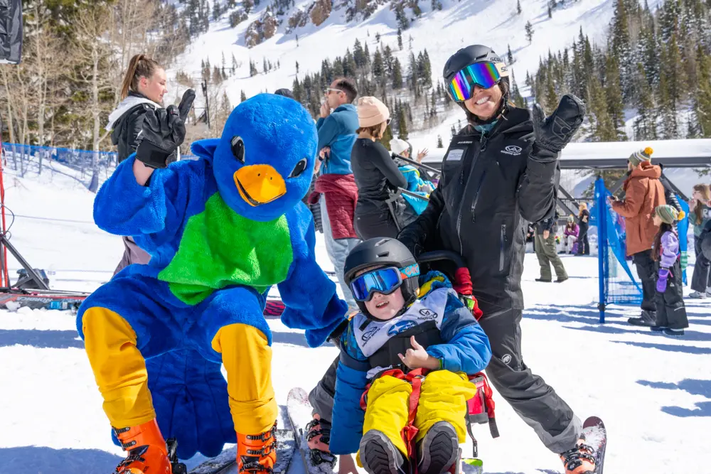 The Bird poses with a kid in a sit ski at the Steve Young Classic, a wasatch adaptive event at Snowbird