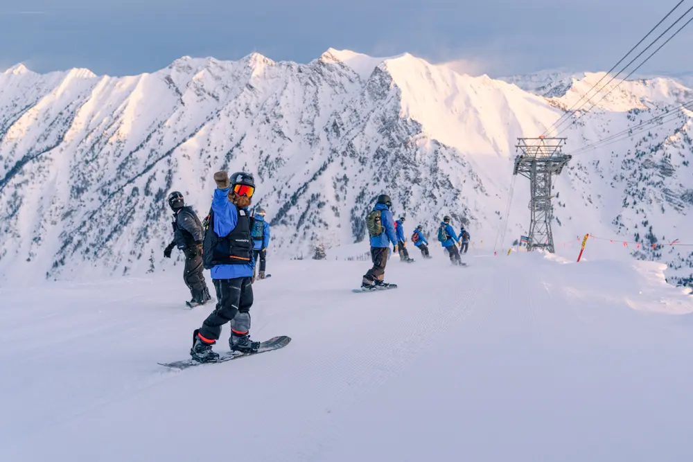 Employee skiing a groomer at sunrise