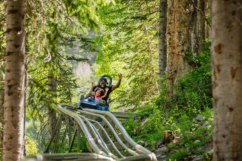 Dad and daughter ride the Mountain Coster at Snowbird, one of the many family-fun activities during summer