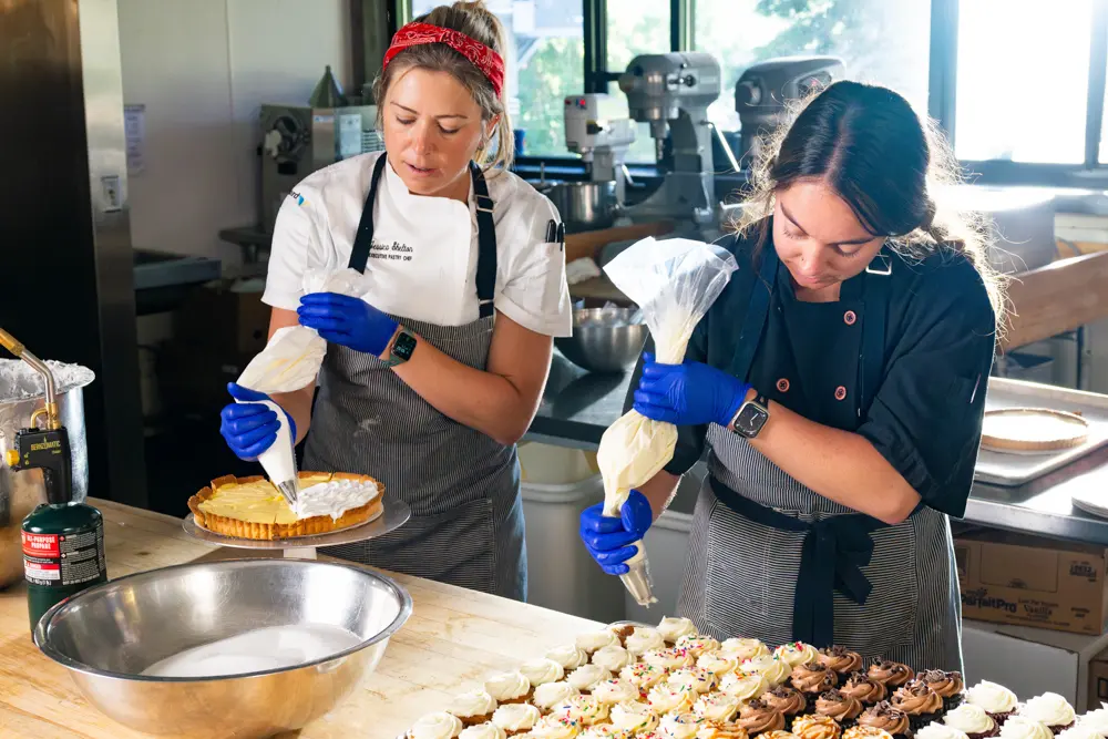 Snowbird baker, one of the many ski industry jobs at Snowbird, pipets filling into pastries