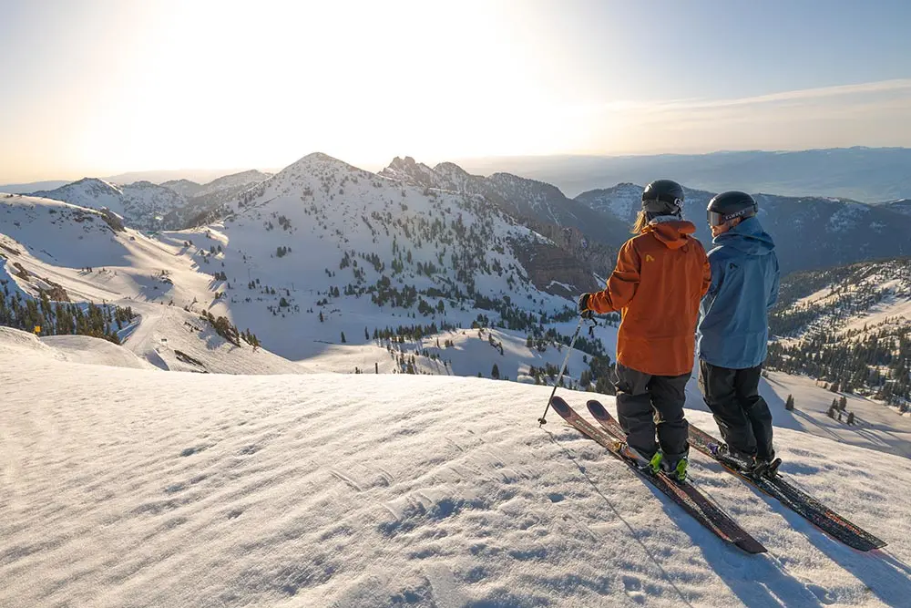 2 skiers look over the mountains in mineral basin during a wedding