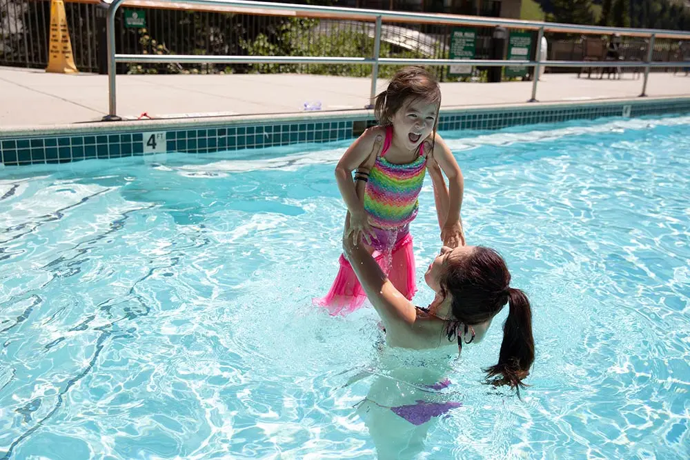 Kid and mom play in the pool at one of Snowbird's lodging properties