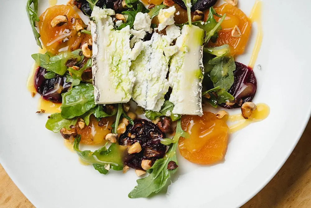 An Aerie salad with fresh fruit and sliced cheese