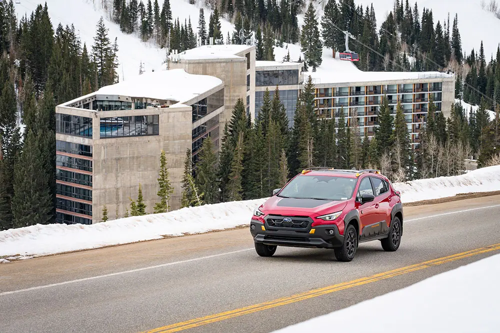 Subaru drives on Little Cottonwood Canyon past The Cliff Lodge