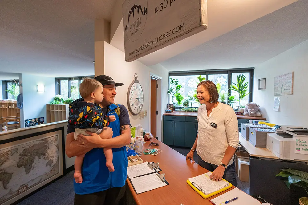 Parent checks in kid to childcare at Snowbird's Superior Childcare