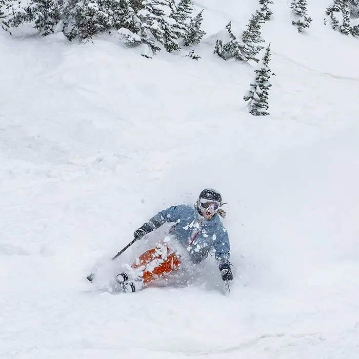 Adaptive athlete with Wasatch Adaptive Sports skis powder with a monoski