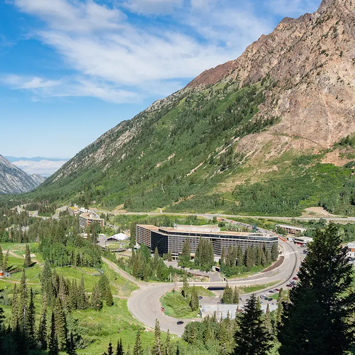 Mobile hero of snowbird's lodging options in the summer, surrounded by the green Little Cottonwood Canyon
