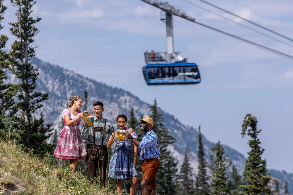 Snowbird's 2025 oktoberfest with guests in lederhosen and dirndl's next to the aerial tram
