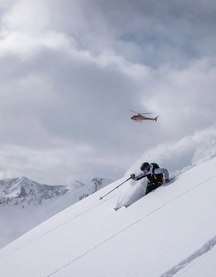 Skier in powder under a helicopter with Powderbird helicopter skiing in Utah, near Snowbird- mobile hero
