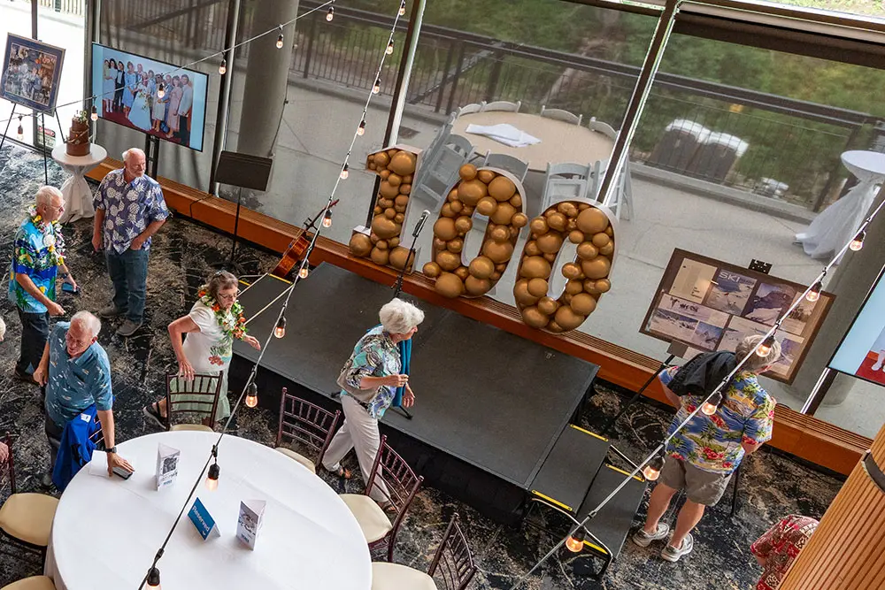 Event technology at Snowbird, people look at screens at 100th birthday party