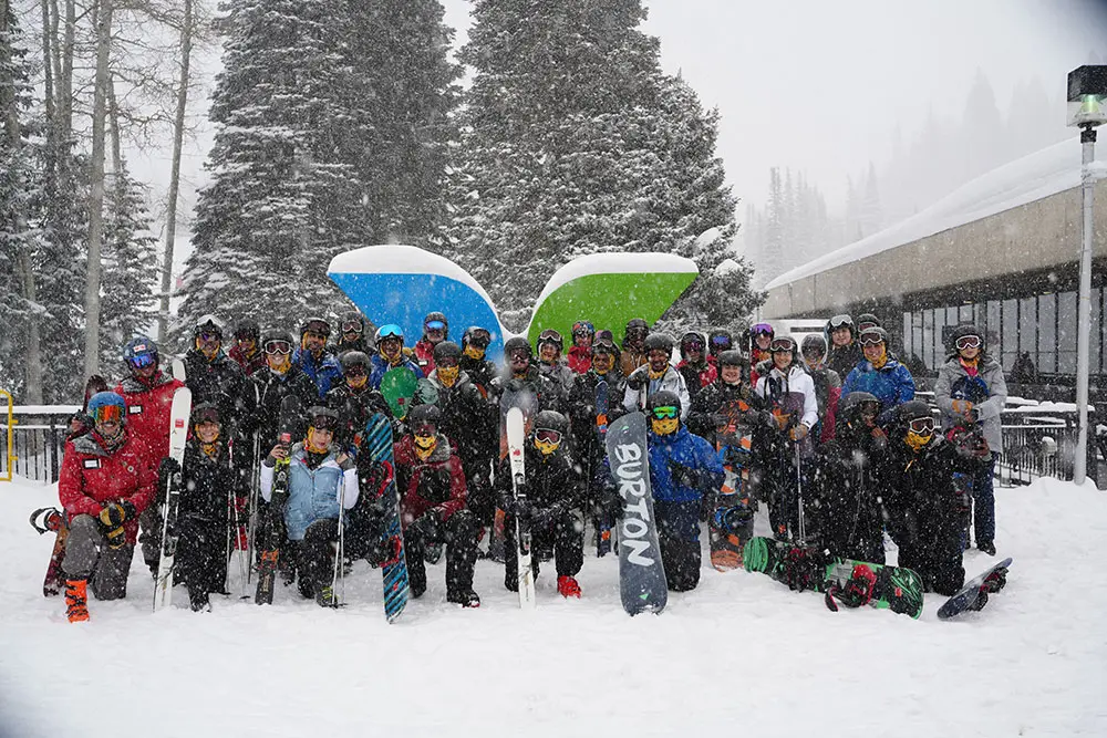 Discover Winter group from Ski Utah poses in front of the Snowbird Wings during a lesson