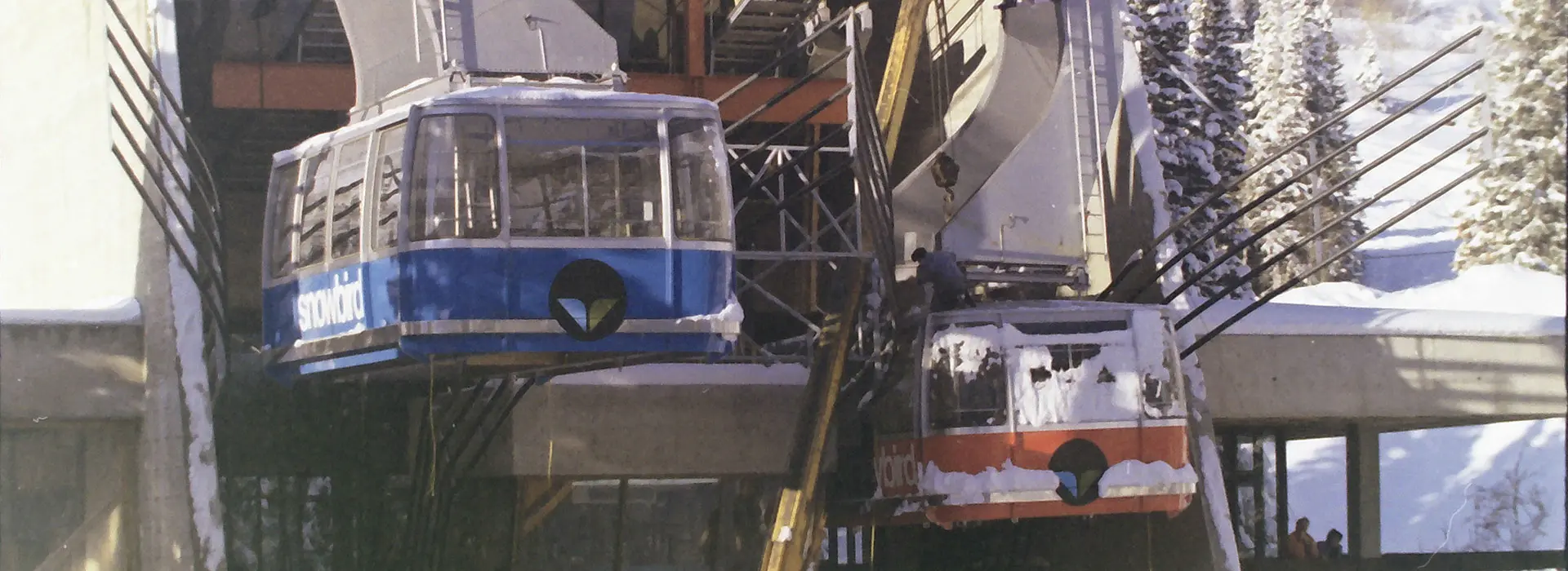 The red and blue original trams getting installed at Snowbird