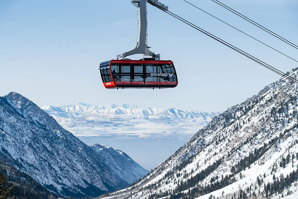 red tram with a canyon view behind, views of the Salt Lake valley. Scenic tram allows you to see it all