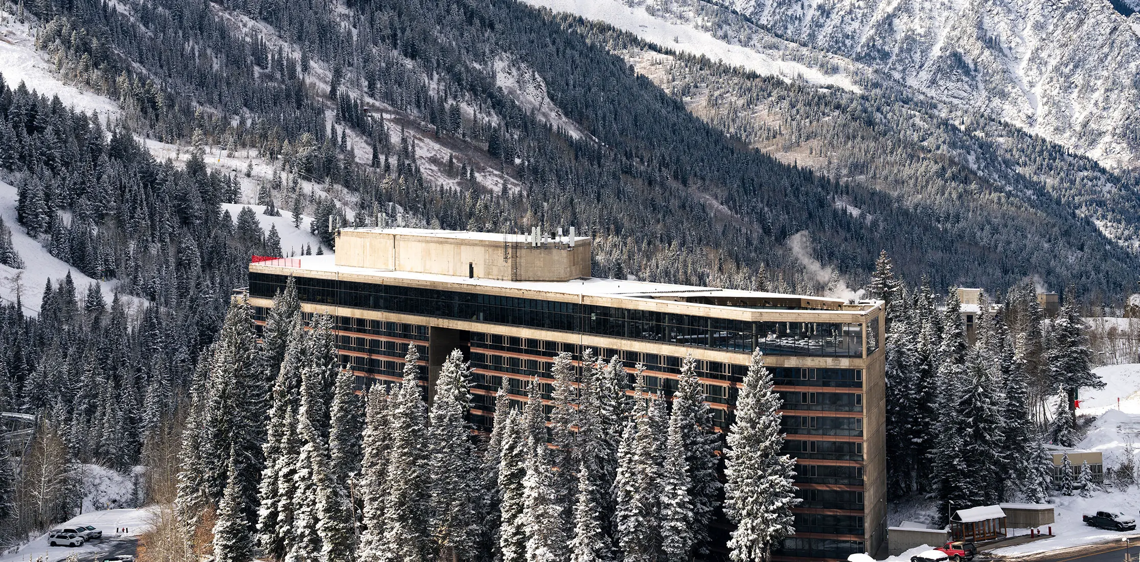 The Cliff Lodge surrounded by snowy trees at Snowbird