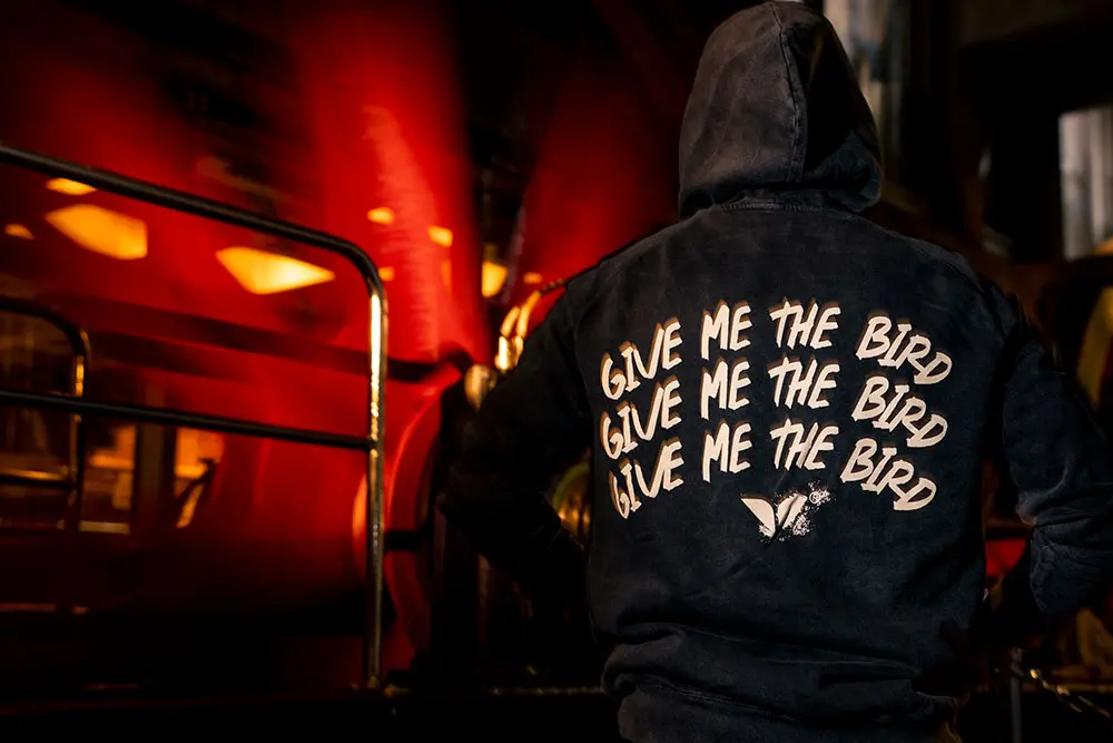 Give me the Bird sweatshirt at Snowbird next to the tram wheel