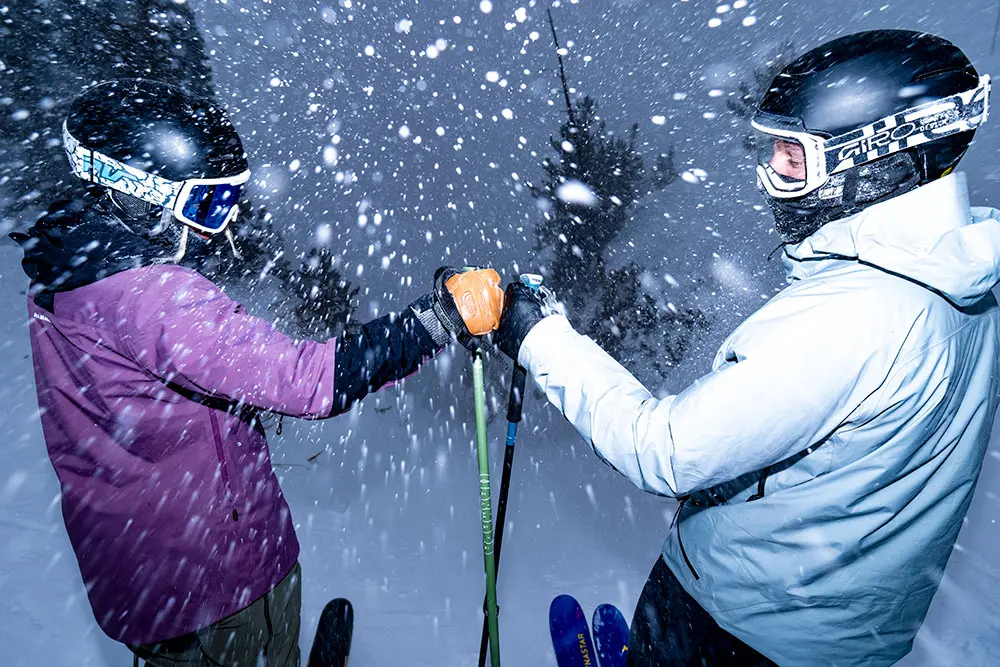 2 skiers fist bumping at Snowbird