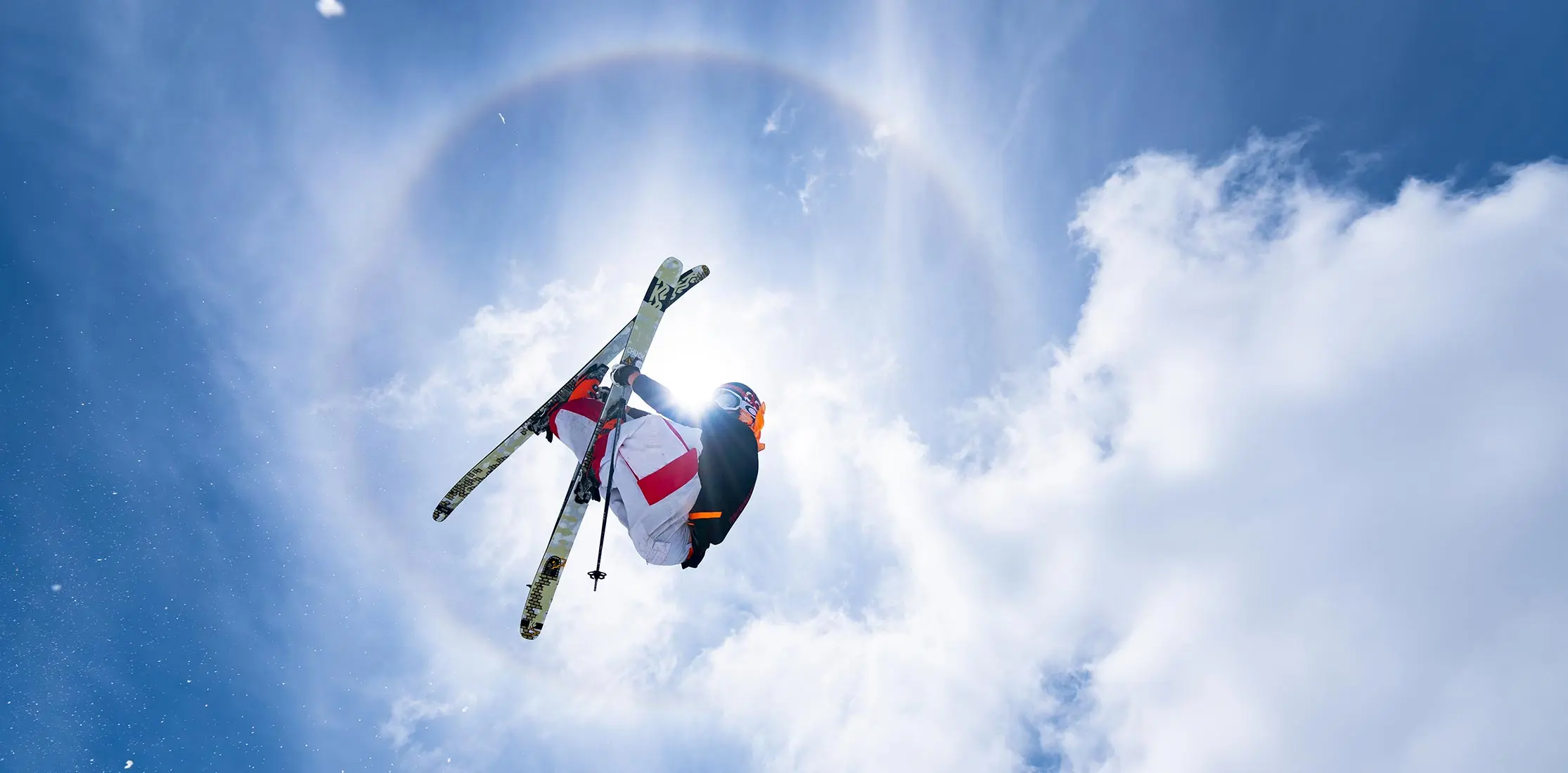 Skier doing a grab in the middle of a sundog off Snowbird's wave