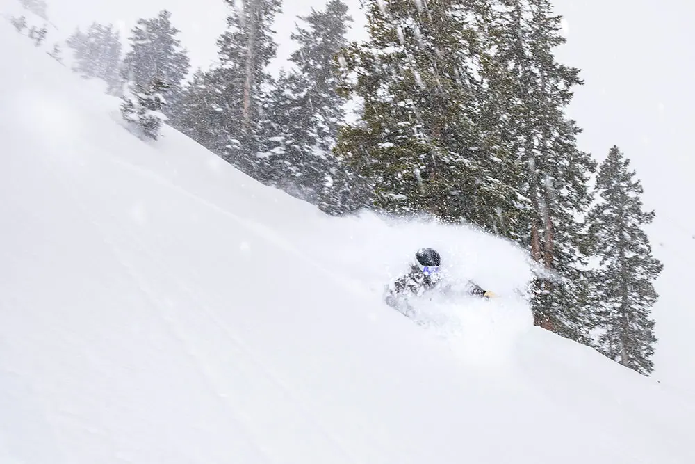 Skier in deep powder during a storm with snow falling around her