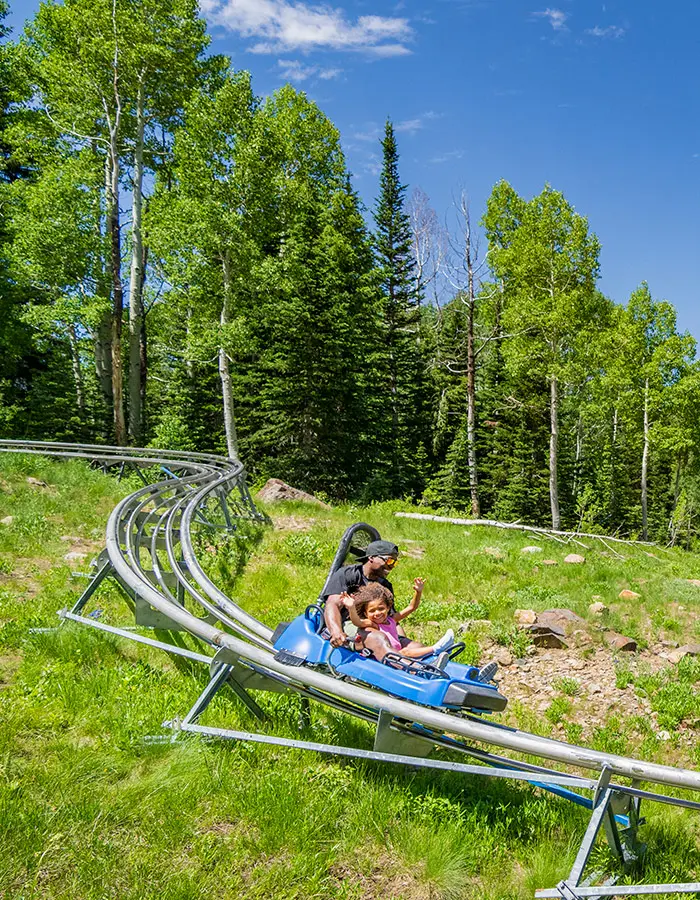 Mobile hero of a family on the Mountain Coaster near the Cliff Lodge on a summer vacation
