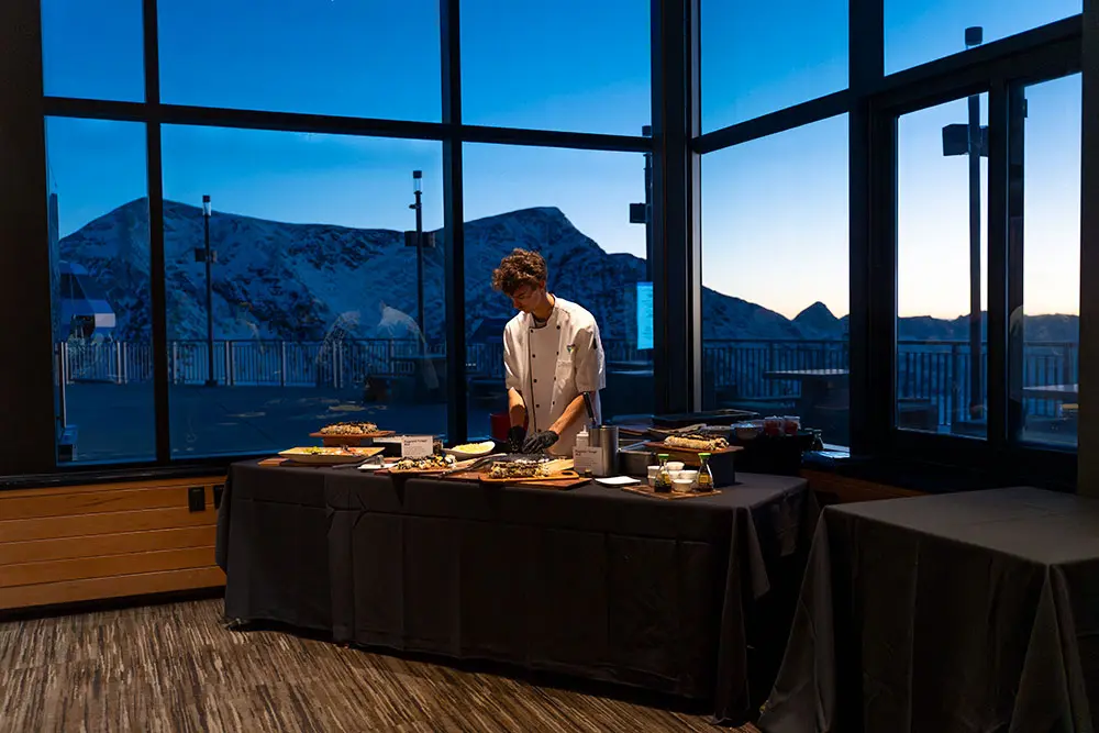 Snowbird employee carves meat during a private dinner party at the summit- one of Snowbird's private dinner venues