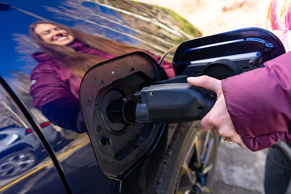 Someone plugs in an EV charger at one of Snowbird's newest EV charging locations