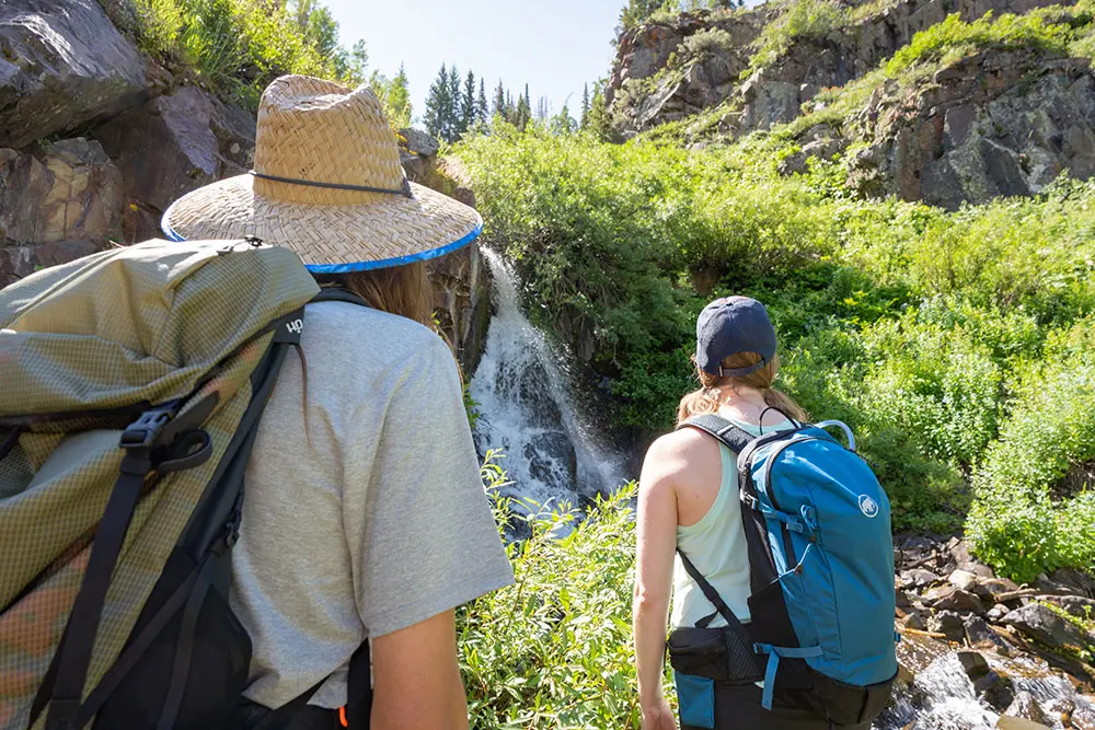 Group of people on a guided hike with Snowbird Mountain Guides look at a waterfall at Snowbird