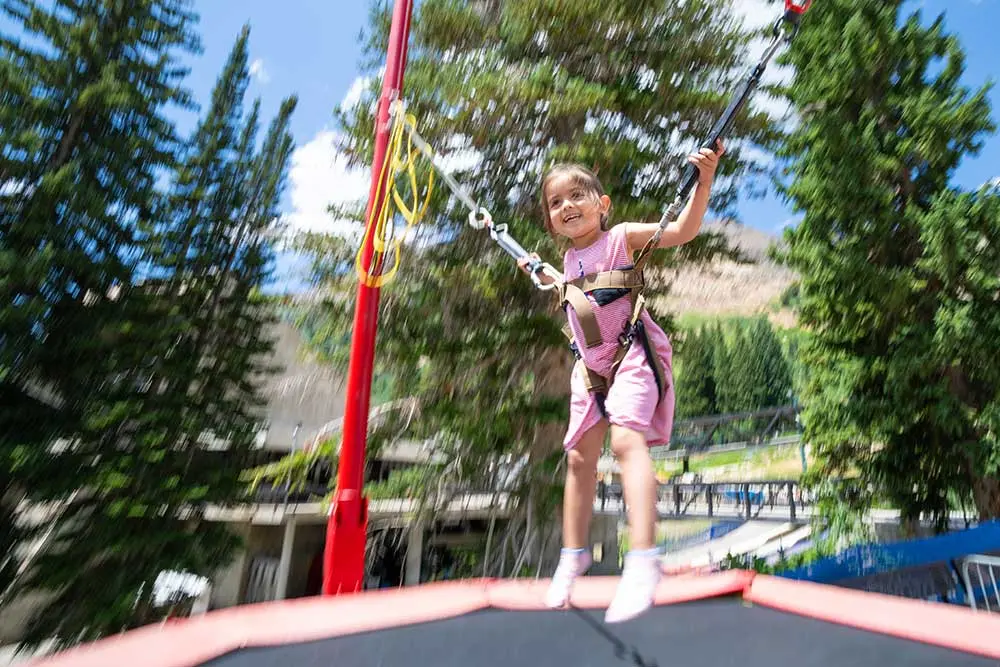 Kid staying at the Inn jumps on the trampoline with Stay & Save discounts