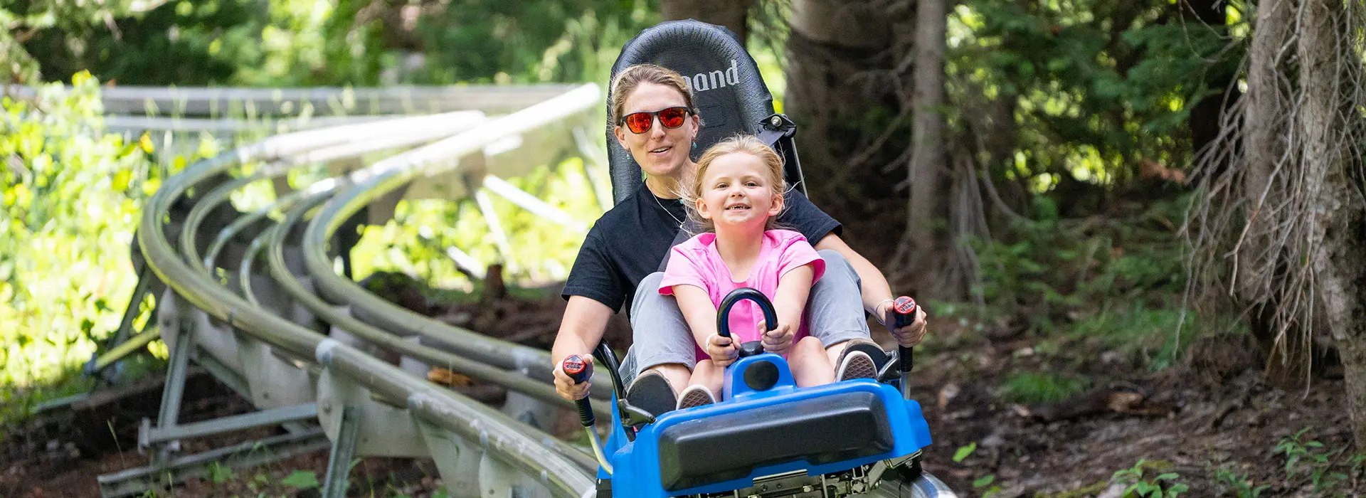 Mother and daughter ride the mountain coaster together- one of Snowbird's many summer activities at the mountain