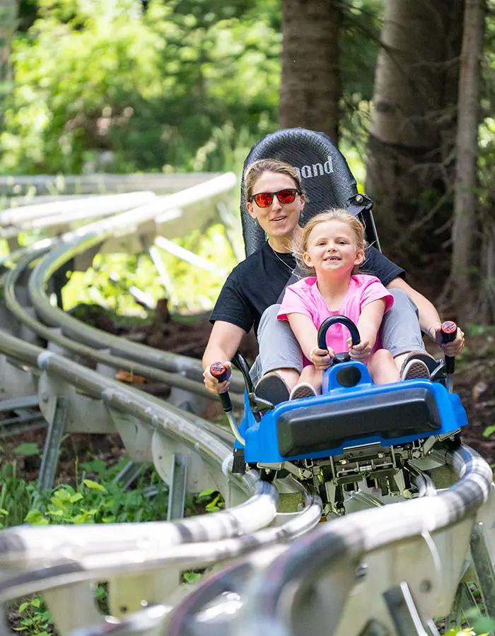 Mobile hero of a mom and daughter riding the mountain coaster together