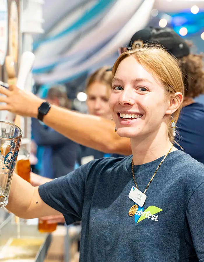 Mobile hero of Snowbird employee pouring beer at Oktoberfest- Snowbird is always hiring mountain jobs