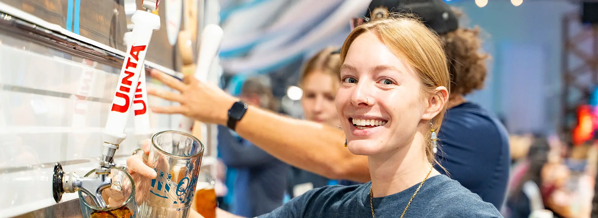 Snowbird employee smiles while pouring beer during Oktoberfest. Snowbird is always hiring for mountain jobs