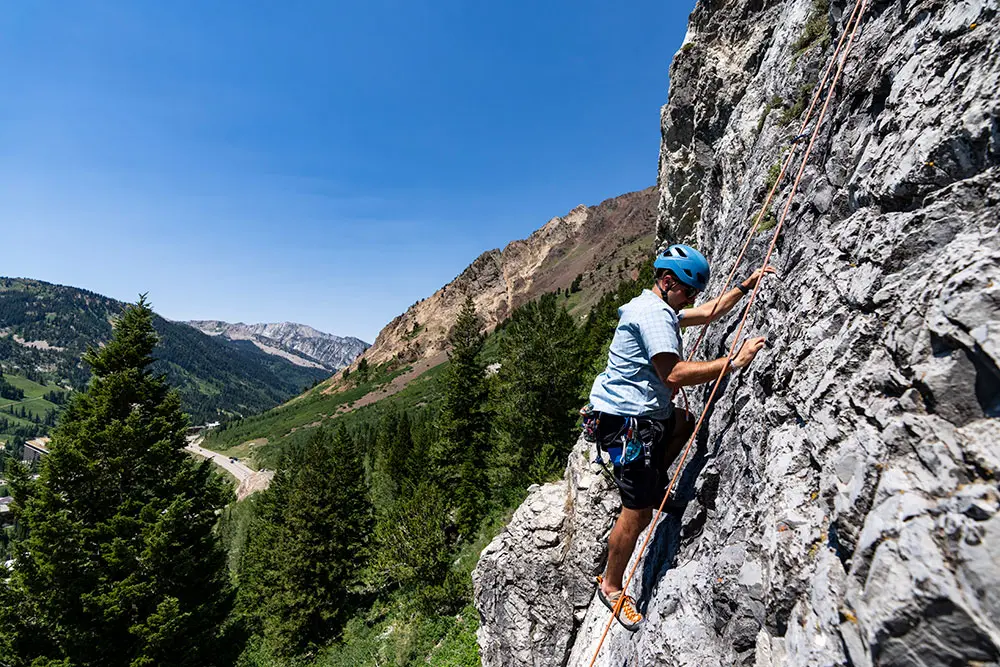 Client climbing above Little Cottonwood road near Snowbird with Snowbird Mountain Guides