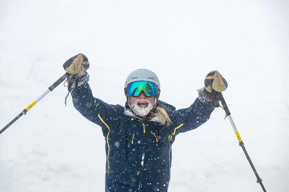 Guy with a senior lift ticket cheers about skiing powder
